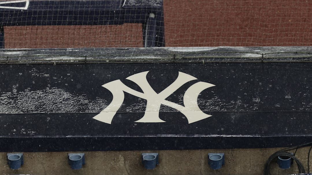 Aug 17, 2020; Bronx, New York, USA; A general view of rain falling on the  New York Yankees logo on the first base dugout roof during a rain delay in the game between the New York Yankees and the Boston Red Sox. Mandatory Credit: Vincent Carchietta-Imagn Images