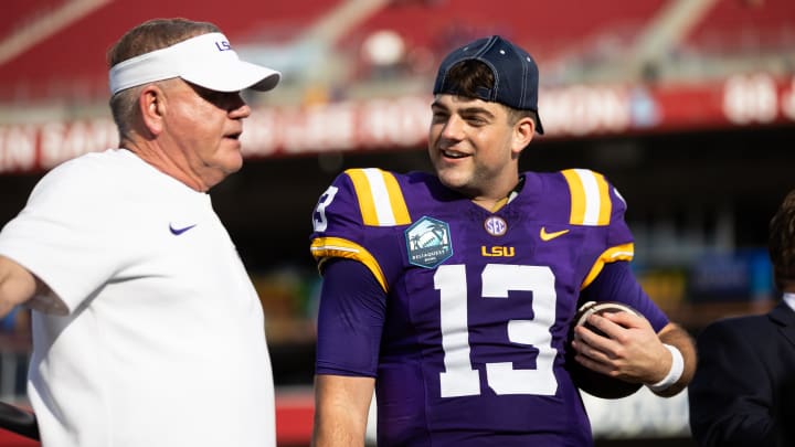 Jan 1, 2024; Tampa, FL, USA; LSU Tigers head coach Brian Kelly and quarterback Garrett Nussmeier (13) talk on the podium after the game against the Wisconsin Badgers at the Reliaquest Bowl at Raymond James Stadium. Mandatory Credit: Matt Pendleton-USA TODAY Sports