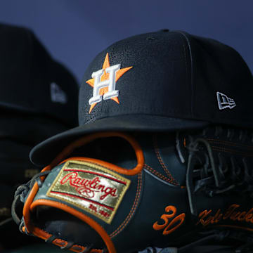 Apr 21, 2023; Atlanta, Georgia, USA; A detailed view of a Houston Astros hat and glove in the dugout against the Atlanta Braves in the fifth inning at Truist Park. 