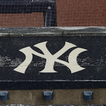 Aug 17, 2020; Bronx, New York, USA; A general view of rain falling on the  New York Yankees logo on the first base dugout roof during a rain delay in the game between the New York Yankees and the Boston Red Sox. Mandatory Credit: Vincent Carchietta-Imagn Images