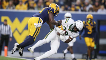 Nov 16, 2024; Morgantown, West Virginia, USA; Baylor Bears running back Bryson Washington (30) catches a pass for a touchdown while defended by West Virginia Mountaineers linebacker Trey Lathan (4) during the first quarter at Mountaineer Field at Milan Puskar Stadium. Mandatory Credit: Ben Queen-Imagn Images