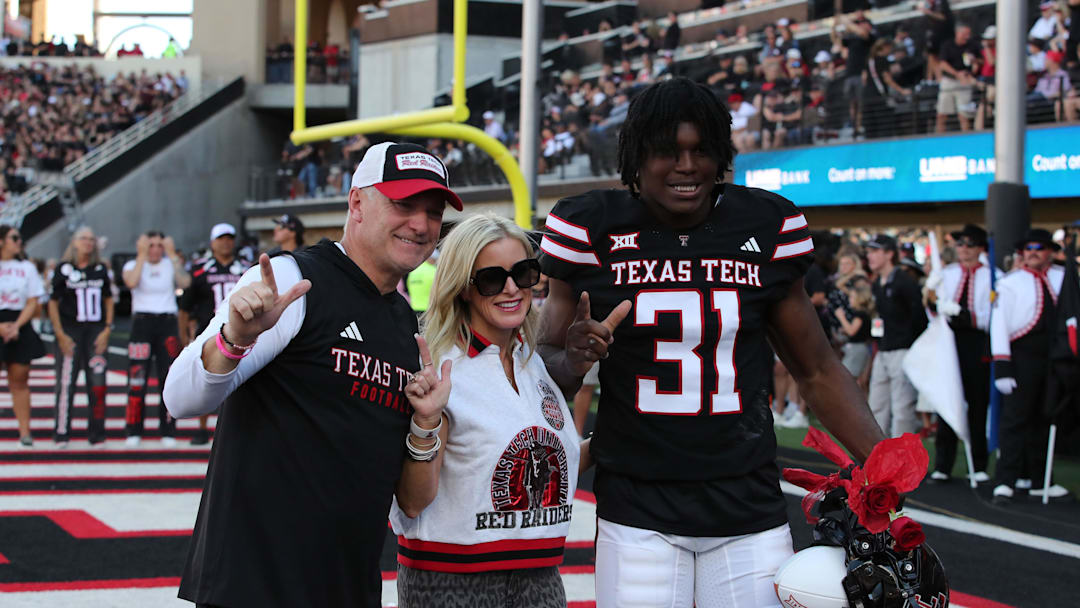 Nov 15, 2025; Lubbock, Texas, USA; Texas Tech Red Raiders head coach Joey McGuire and wife Debbie celebrate senior day with Texas Tech Red Raiders defensive end David Bailey (31) before the game against the Central Florida Knights at Jones AT&T Stadium. Mandatory Credit: Michael C. Johnson-Imagn Images Nov 15, 2025; Lubbock, Texas, USA; Texas Tech Red Raiders head coach Joey McGuire and wife Debbie celebrate senior day with Texas Tech Red Raiders defensive end David Bailey (31) before the game against the Central Florida Knights at Jones AT&T Stadium. Mandatory Credit: Michael C. Johnson-Imagn Images