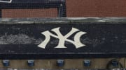 Aug 17, 2020; Bronx, New York, USA; A general view of rain falling on the  New York Yankees logo on the first base dugout roof during a rain delay in the game between the New York Yankees and the Boston Red Sox. Mandatory Credit: Vincent Carchietta-USA TODAY Sports