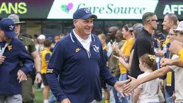 Sep 27, 2025; Morgantown, West Virginia, USA; West Virginia Mountaineers head coach Rich Rodriguez walks on the field and greets fans before their game against the Utah Utes at Milan Puskar Stadium. Mandatory Credit: Ben Queen-Imagn Images