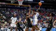 Mar 21, 2024; Pittsburgh, PA, USA; Kentucky Wildcats guard Antonio Reeves (12) jumps to shoot the ball while Oakland Golden Grizzlies forward Tuburu Naivalurua (12) blocks during the second half in the first round of the 2024 NCAA Tournament at PPG Paints Arena.