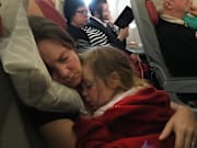 A mother and daughter during a flight from New York to Rome.
