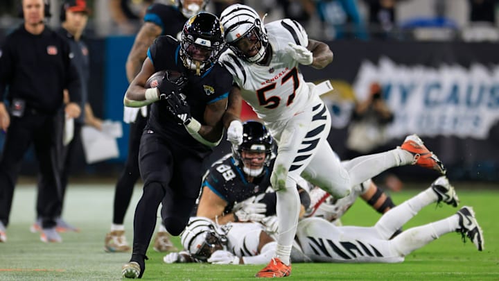 Jacksonville Jaguars running back Travis Etienne Jr. (1) rushes for yards as Cincinnati Bengals linebacker Germaine Pratt (57) makes the hit during overtime of a regular season NFL football matchup Monday, Dec. 4, 2023 at EverBank Stadium in Jacksonville, Fla. The Cincinnati Bengals defeated the Jacksonville Jaguars 34-31 in overtime. [Corey Perrine/Florida Times-Union]