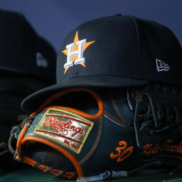 Apr 21, 2023; Atlanta, Georgia, USA; A detailed view of a Houston Astros hat and glove in the dugout against the Atlanta Braves in the fifth inning at Truist Park.
