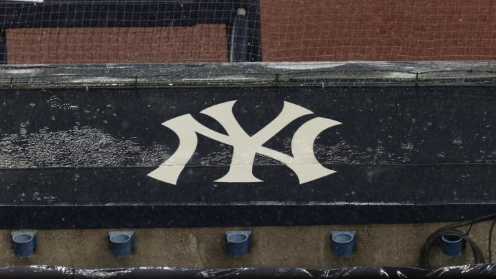 Aug 17, 2020; Bronx, New York, USA; A general view of rain falling on the  New York Yankees logo on the first base dugout roof during a rain delay in the game between the New York Yankees and the Boston Red Sox. Mandatory Credit: Vincent Carchietta-USA TODAY Sports