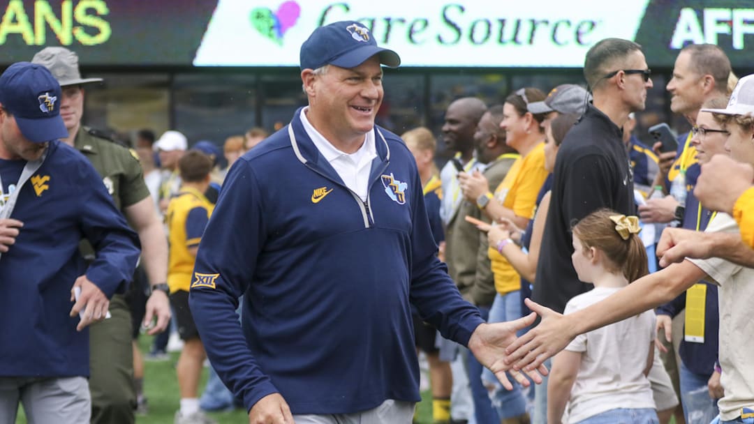 Sep 27, 2025; Morgantown, West Virginia, USA; West Virginia Mountaineers head coach Rich Rodriguez walks on the field and greets fans before their game against the Utah Utes at Milan Puskar Stadium. Mandatory Credit: Ben Queen-Imagn Images