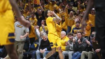 Feb 19, 2025; Morgantown, West Virginia, USA; West Virginia Mountaineers guard Jonathan Powell (11) celebrates after a made three point shot during the second half against the Cincinnati Bearcats at WVU Coliseum. Mandatory Credit: Ben Queen-Imagn Images
