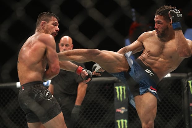 Kevin Lee lands a kick against Rafael dos Anjos.