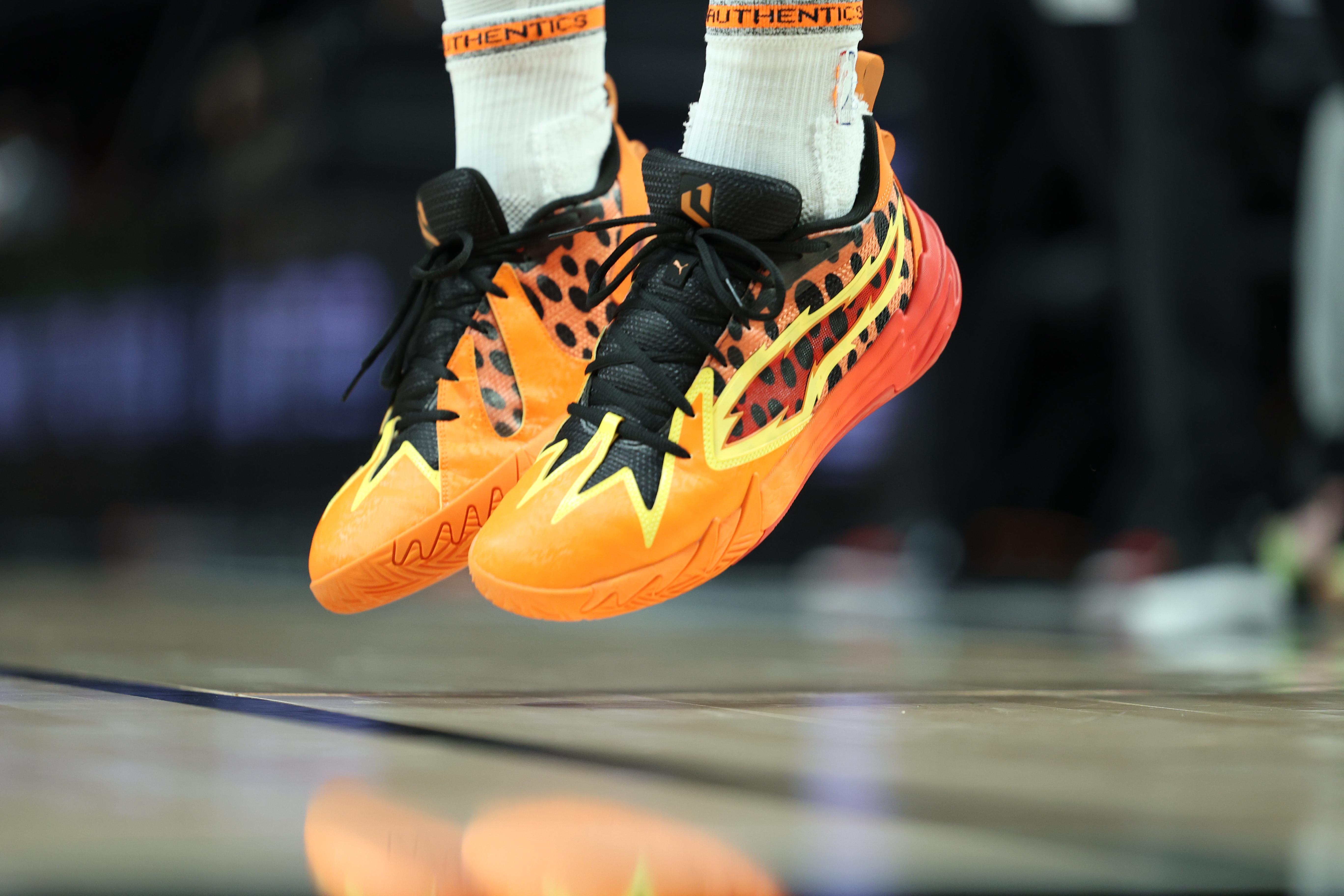 Portland Trail Blazers guard Scoot Henderson's orange and black PUMA sneakers.