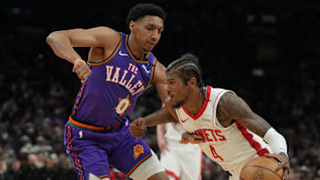 Mar 30, 2025; Phoenix, Arizona, USA; Houston Rockets guard Jalen Green (4) drives on Phoenix Suns forward Ryan Dunn (0) in the first half at Footprint Center. Mandatory Credit: Rick Scuteri-Imagn Images