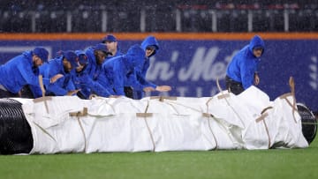 Sep 28, 2023; New York City, New York, USA; New York Mets grounds crew roll out the tarp during a rain delay during the ninth inning against the Miami Marlins at Citi Field. Mandatory Credit: Brad Penner-USA TODAY Sports