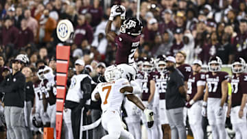 Nov 30, 2024; College Station, Texas, USA; Texas A&M Aggies wide receiver Terry Bussey (2) leaps to catch a pass over Texas Longhorns defensive back Jahdae Barron (7) during the first half. The Longhorns defeated the Aggies 17-7 at Kyle Field. Mandatory Credit: Maria Lysaker-Imagn Images  