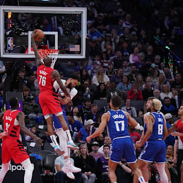 Apr 14, 2024; Sacramento, California, USA; Portland Trail Blazers guard Taze Moore (76) dunks over Sacramento Kings center JaVale McGee (00) in the fourth quarter at the Golden 1 Center. Mandatory Credit: Cary Edmondson-Imagn Images