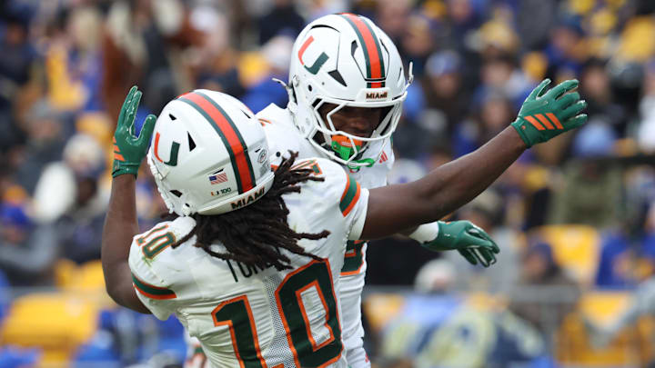 Nov 29, 2025; Pittsburgh, Pennsylvania, USA;  Miami Hurricanes wide receiver Malachi Toney (10) and running back CharMar Brown (right) celebrate a touchdown against the Pittsburgh Panthers during the third quarter at Acrisure Stadium. Mandatory Credit: Charles LeClaire-Imagn Images