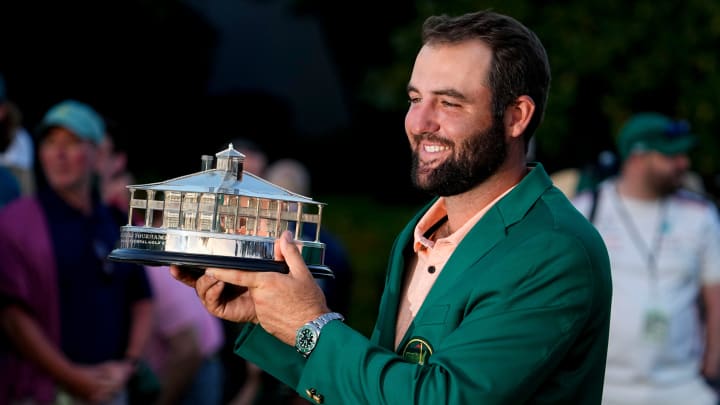 Apr 14, 2024; Augusta, Georgia, USA; Scottie Scheffler holds up his trophy at the green jacket ceremony after winning the Masters Tournament. Mandatory Credit: Adam Cairns-USA TODAY Network