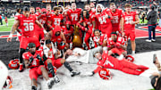 UNLV Rebels head coach Dan Mullen and his players pose with the Golden Pineapple trophy after the Rebels defeated the Hawaii Rainbow Warriors 38-10 at Allegiant Stadium. Mandatory Credit: Stephen R. Sylvanie-Imagn Images