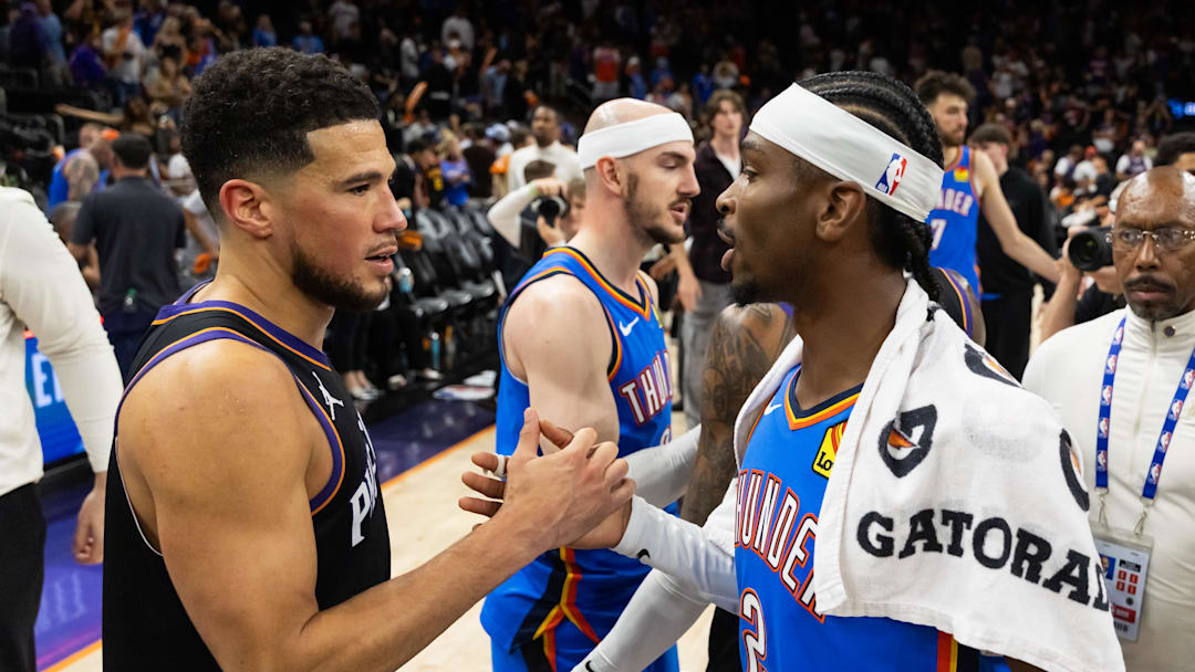 Apr 27, 2026; Phoenix, Arizona, USA; Oklahoma City Thunder guard Shai Gilgeous-Alexander (2) greets Phoenix Suns guard Devin Booker (1) after advancing in a four game sweep of the first round of the 2026 NBA Playoffs at Mortgage Matchup Center. Mandatory Credit: Mark J. Rebilas-Imagn Images