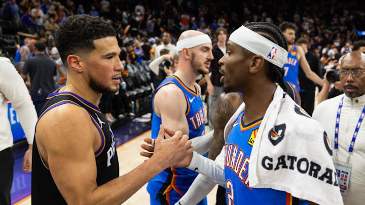 Apr 27, 2026; Phoenix, Arizona, USA; Oklahoma City Thunder guard Shai Gilgeous-Alexander (2) greets Phoenix Suns guard Devin Booker (1) after advancing in a four game sweep of the first round of the 2026 NBA Playoffs at Mortgage Matchup Center. Mandatory Credit: Mark J. Rebilas-Imagn Images