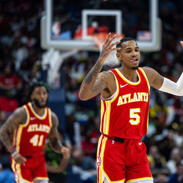 Nov 4, 2023; New Orleans, Louisiana, USA;  Atlanta Hawks guard Dejounte Murray (5) reacts to making a three point basket against New Orleans Pelicans guard Kira Lewis Jr. (13) during the second half at Smoothie King Center. Mandatory Credit: Stephen Lew-USA TODAY Sports
