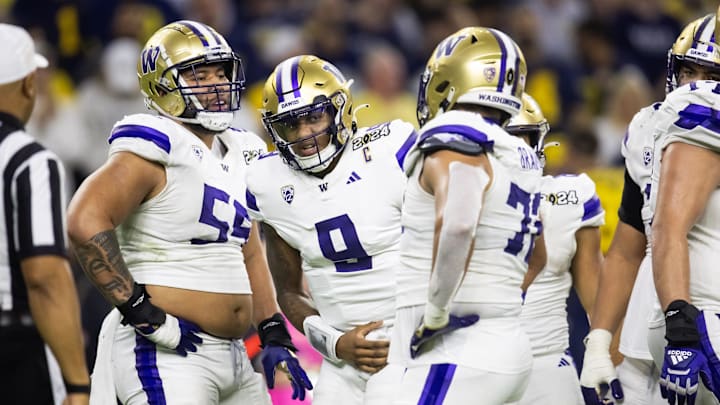 Jan 8, 2024; Houston, TX, USA; Washington Huskies quarterback Michael Penix Jr. reacts with teammates, including offensive lineman Troy Fautanu.