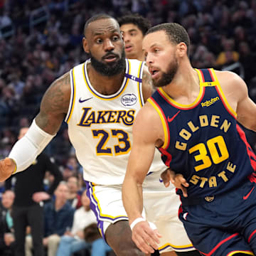 Jan 25, 2025; San Francisco, California, USA; Golden State Warriors guard Stephen Curry (30) dribbles against Los Angeles Lakers forward LeBron James (23) during the third quarter at Chase Center. Mandatory Credit: Darren Yamashita-Imagn Images