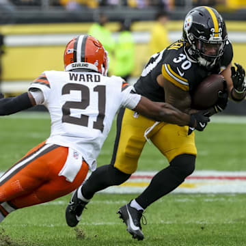 Oct 12, 2025; Pittsburgh, Pennsylvania, USA; Pittsburgh Steelers running back Jaylen Warren (30) runs the ball while Cleveland Browns cornerback Denzel Ward (21) defends during the first quarter at Acrisure Stadium. Mandatory Credit: Charles LeClaire-Imagn Images