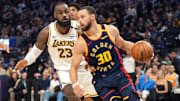 Golden State Warriors guard Stephen Curry dribbles against Los Angeles Lakers forward LeBron James.