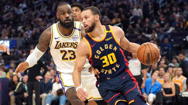 Golden State Warriors guard Stephen Curry dribbles against Los Angeles Lakers forward LeBron James.
