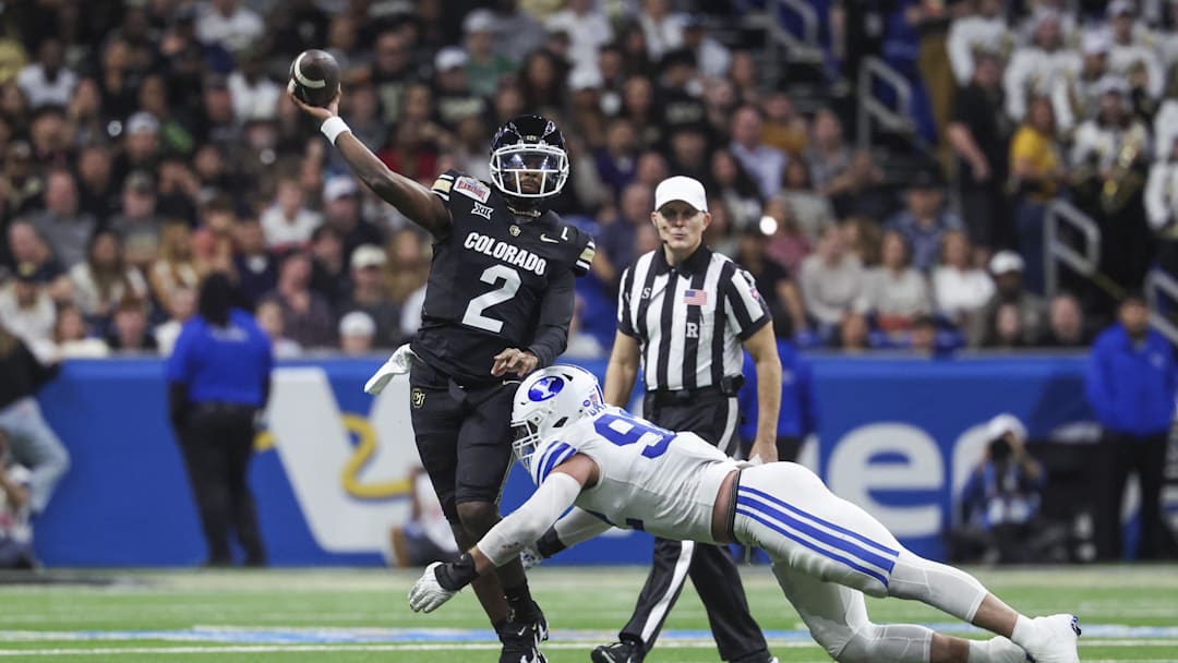 Dec 28, 2024; San Antonio, TX, USA; Colorado Buffaloes quarterback Shedeur Sanders (2) attempts a pass as Brigham Young Cougars defensive end Tyler Batty (92) attempts to make a tackle during the third quarter at Alamodome. Dec 28, 2024; San Antonio, TX, USA; Colorado Buffaloes quarterback Shedeur Sanders (2) attempts a pass as Brigham Young Cougars defensive end Tyler Batty (92) attempts to make a tackle during the third quarter at Alamodome.