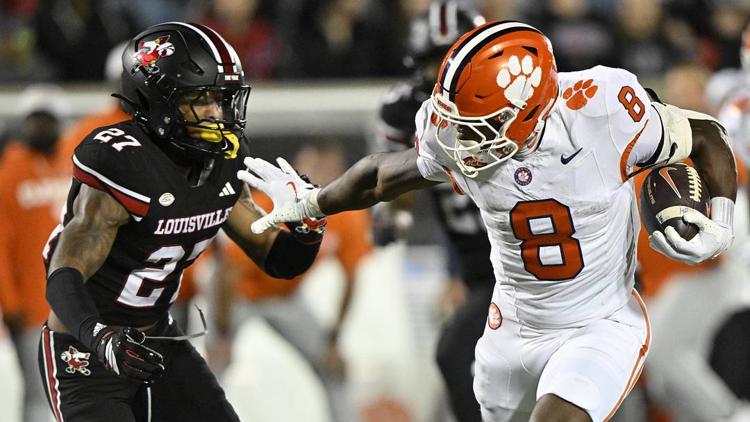 Nov 14, 2025; Louisville, Kentucky, USA; Clemson Tigers running back Adam Randall (8) runs the ball against Louisville Cardinals defensive back Jojo Evans Jr. (27) during the first half at L&N Federal Credit Union Stadium. Clemson defeated Louisville 20-19. Mandatory Credit: Jamie Rhodes-Imagn Images