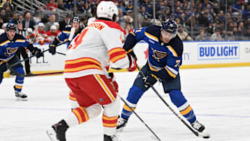 Jan 14, 2025; St. Louis, Missouri, USA; Calgary Flames defenseman Rasmus Andersson (4) defends against St. Louis Blues right wing Mathieu Joseph (71) as he takes a shot in the second period at Enterprise Center. Mandatory Credit: Joe Puetz-Imagn Images