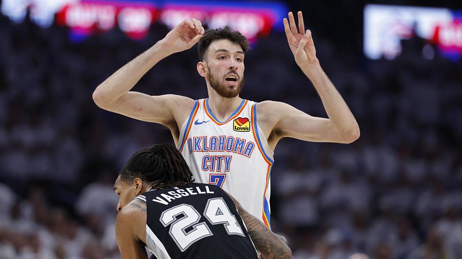 Oklahoma City Thunder center Chet Holmgren calls a play against San Antonio Spurs guard Devin Vassell.
