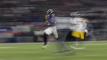 Jan 11, 2025; Baltimore, Maryland, USA; Baltimore Ravens running back Derrick Henry (22) scores a touchdown as Pittsburgh Steelers cornerback James Pierre (42) chases during the third quarter in an AFC wild card game at M&T Bank Stadium. Mandatory Credit: Geoff Burke-Imagn Images
