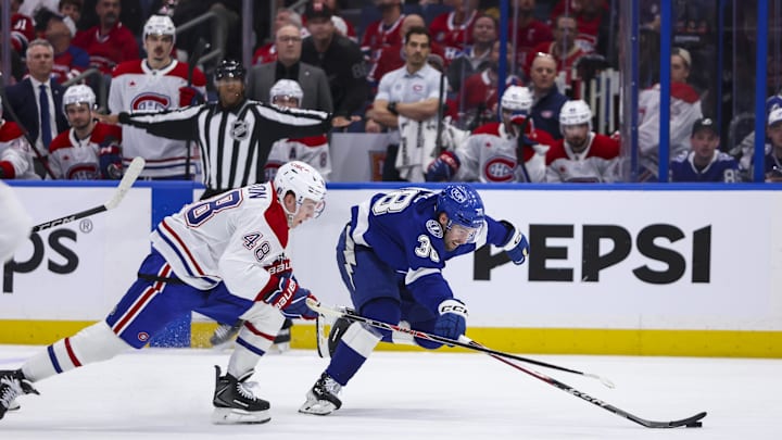 Apr 19, 2026; Tampa, Florida, USA; Tampa Bay Lightning forward Brandon Hagel (38) reaches for the puck under pressure from Montreal Canadiens defenseman Lane Hutson (48) during the third period in game one of the first round of the 2026 Stanley Cup Playoffs at Benchmark International Arena. Mandatory Credit: Morgan Tencza-Imagn Images