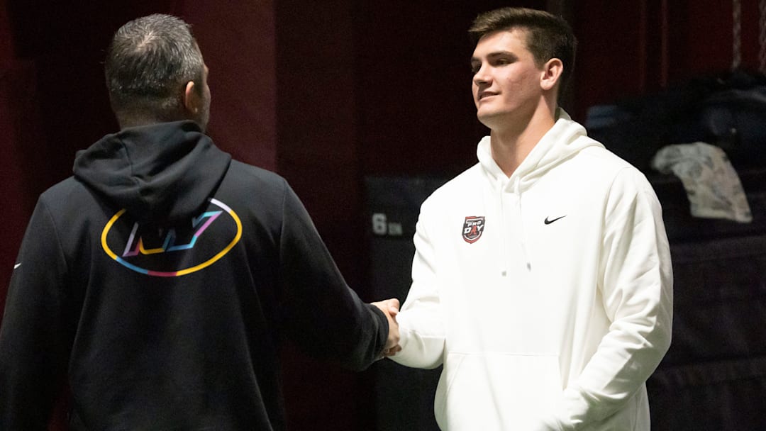 March 25, 2026; Tuscaloosa, AL, USA; Quarterback Ty Simpson talks to a scout during Pro Day in the Hank Crisp Indoor Practice Facility at the University of Alabama.