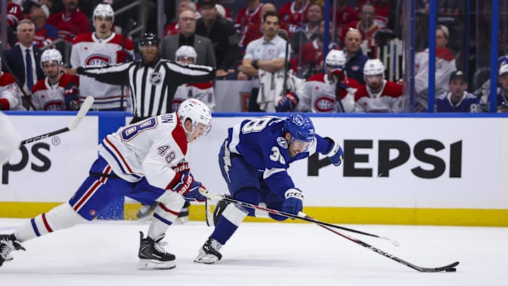Apr 19, 2026; Tampa, Florida, USA; Tampa Bay Lightning forward Brandon Hagel (38) reaches for the puck under pressure from Montreal Canadiens defenseman Lane Hutson (48) during the third period in game one of the first round of the 2026 Stanley Cup Playoffs at Benchmark International Arena. Mandatory Credit: Morgan Tencza-Imagn Images