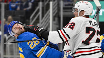Mar 22, 2025; St. Louis, Missouri, USA;  Chicago Blackhawks defenseman Alex Vlasic (72) punches St. Louis Blues left wing Nathan Walker (26) during the second period at Enterprise Center. Mandatory Credit: Jeff Curry-Imagn Images
