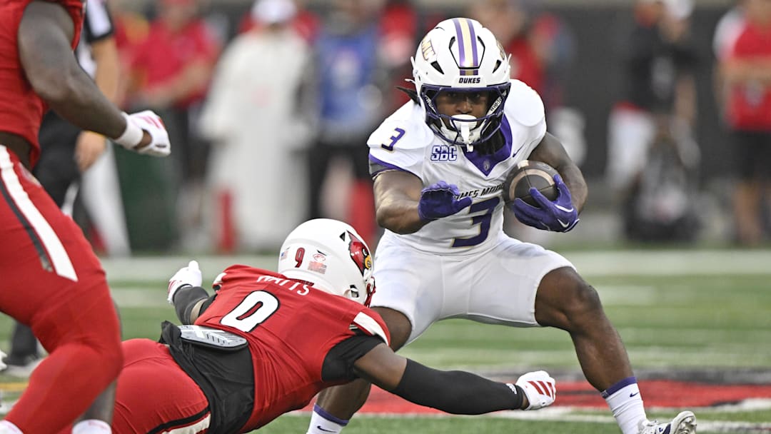 Sep 5, 2025; Louisville, Kentucky, USA;  James Madison Dukes running back Wayne Knight (3) tries to avoid the tackle of Louisville Cardinals linebacker Antonio Watts (9) during the first half at L&N Federal Credit Union Stadium. Louisville defeated James Madison 28-14. Mandatory Credit: Jamie Rhodes-Imagn Images