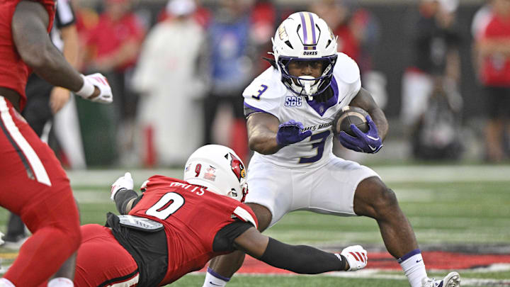 Sep 5, 2025; Louisville, Kentucky, USA;  James Madison Dukes running back Wayne Knight (3) tries to avoid the tackle of Louisville Cardinals linebacker Antonio Watts (9) during the first half at L&N Federal Credit Union Stadium. Louisville defeated James Madison 28-14. Mandatory Credit: Jamie Rhodes-Imagn Images