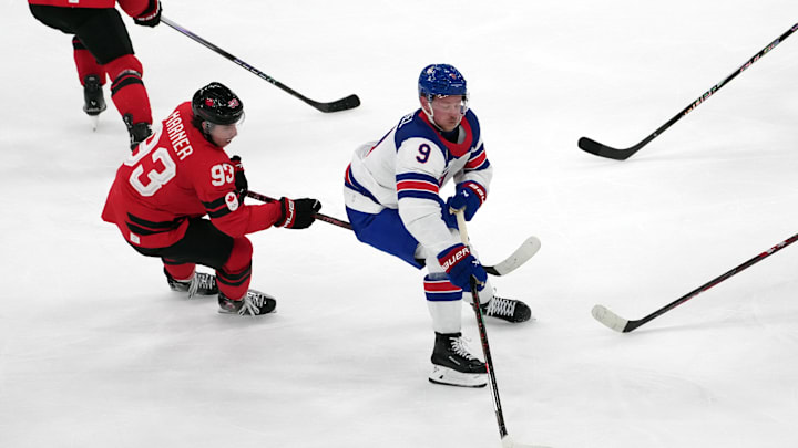 Feb 22, 2026; Milan, Italy; Jack Eichel (9) of the United States skates with the puck as Nick Suzuki (10), Mitch Marner  (93), Shea Theodore  (27) and Thomas Harley  (20) defend during the men's ice hockey gold medal game during the Milano Cortina 2026 Olympic Winter Games at Milano Santagiulia Ice Hockey Arena. Mandatory Credit: James Lang-Imagn Images