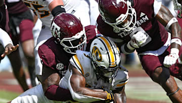 Oct 5, 2024; College Station, Texas, USA; Texas A&M Aggies defensive lineman Albert Regis (17) and linebacker Scooby Williams (0) stop Missouri Tigers running back Marcus Carroll (9) in the fourth quarter at Kyle Field. Mandatory Credit: Maria Lysaker-Imagn Images. 
