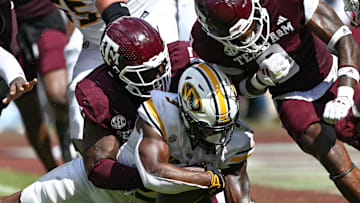 Oct 5, 2024; College Station, Texas, USA; Texas A&M Aggies defensive lineman Albert Regis (17) and linebacker Scooby Williams (0) stop Missouri Tigers running back Marcus Carroll (9) in the fourth quarter at Kyle Field. Mandatory Credit: Maria Lysaker-Imagn Images. 
