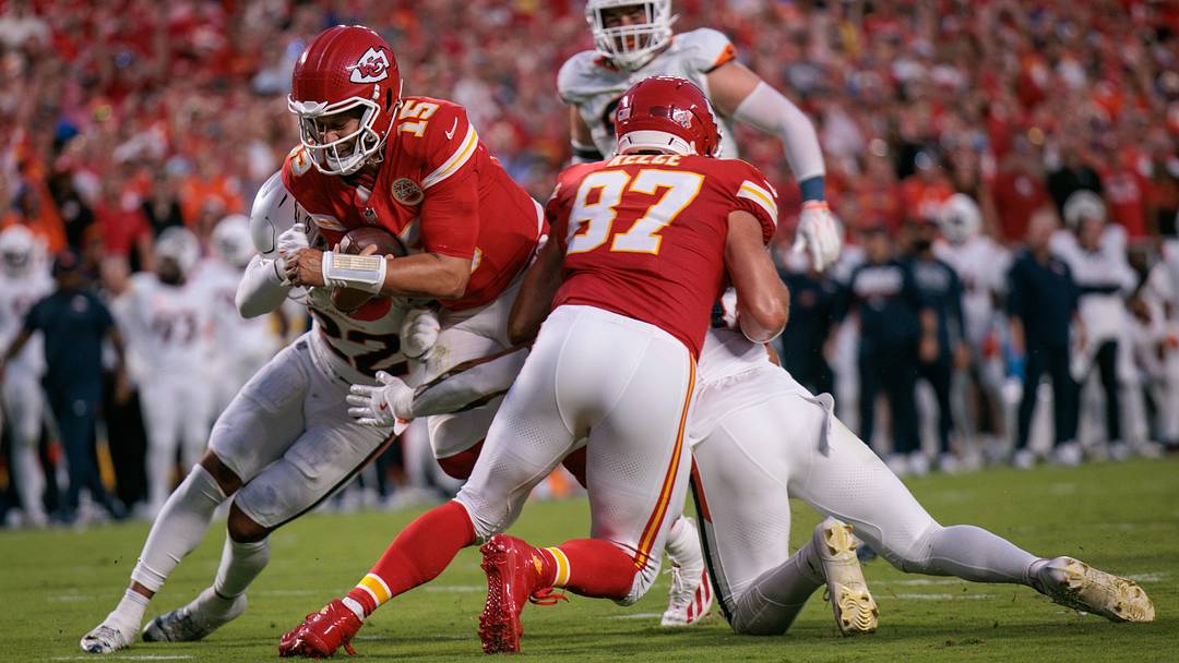 KANSAS CITY, MO - SEPTEMBER 14: Kansas City Chiefs quarterback Patrick Mahomes dives for the end zone while Travis Kelce holds Denver Broncos safety Talanoa Hufanga. 
