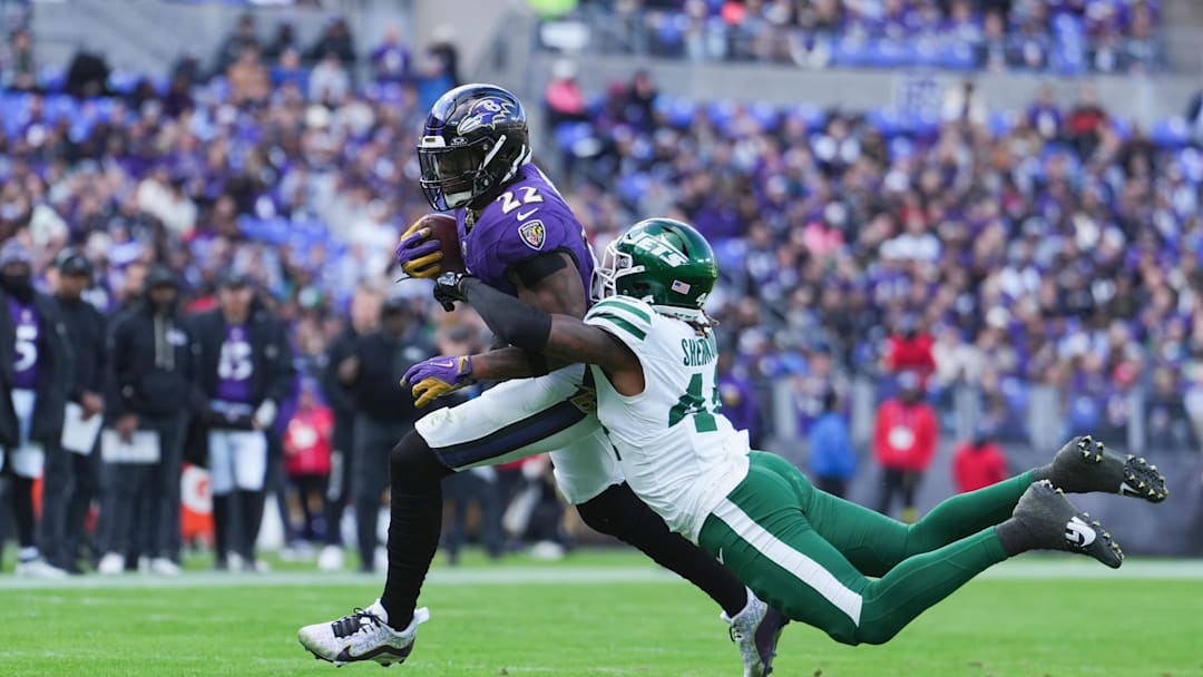 Nov 23, 2025; Baltimore, Maryland, USA; Baltimore Ravens running back Derrick Henry (22) rushes and is tackled by New York Jets linebacker Jamien Sherwood (44) during the second quarter at M&T Bank Stadium. Mandatory Credit: Mitch Stringer-Imagn Images