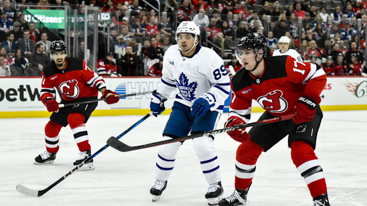 Apr 9, 2024; Newark, New Jersey, USA; New Jersey Devils defenseman Simon Nemec (17) skates past Toronto Maple Leafs left wing Nicholas Robertson (89) during the third period at Prudential Center. Mandatory Credit: John Jones-Imagn Images