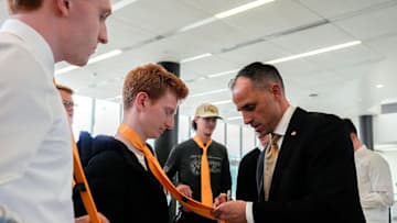 Iowa head men's basketball coach Ben McCollum signs the tie of a Hawks Nest member after his introductory press conference Tuesday, March 25, 2025 at Carver-Hawkeye Arena in Iowa City, Iowa.